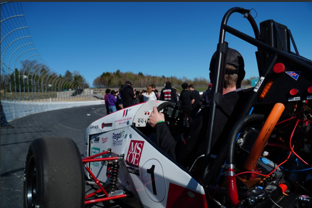 View from behind the cockpit of the Mozee Motorsports formula car lined up on a race track at competition